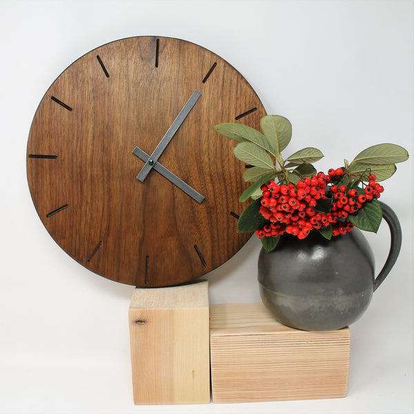 round dark wooden wall clock with black metallic hands