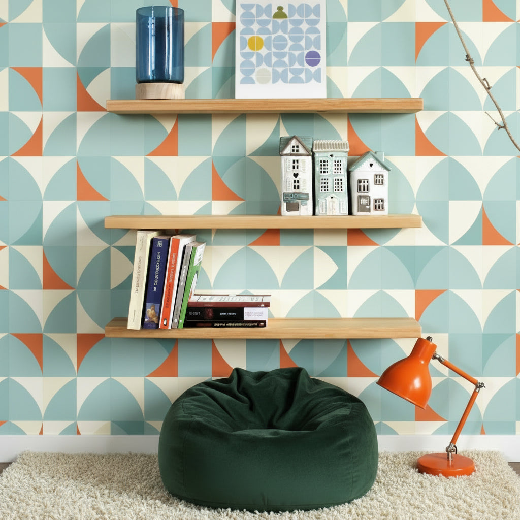 Three light natural wood floating shelves mounted on a white wall, styled with a blue glass vase, a geometric art print, three small house figurines, and a set of books.