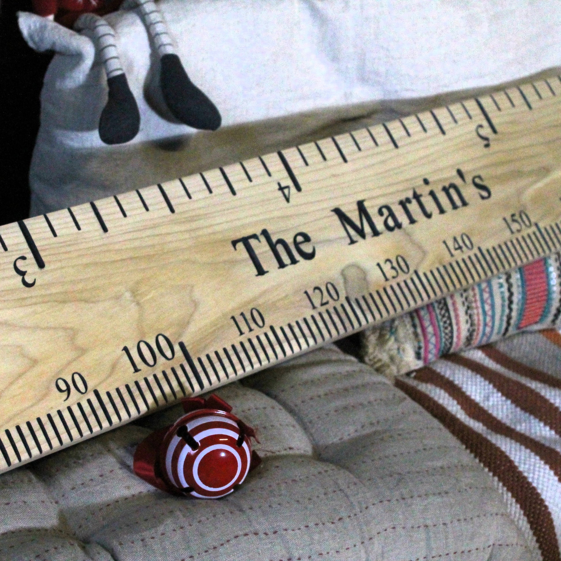 Wooden ruler with 'The Martin's' engraving on a textured surface