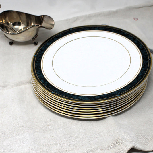 Stack of Royal Doulton Biltmore dinner plates with a silver gravy boat on a white cloth background