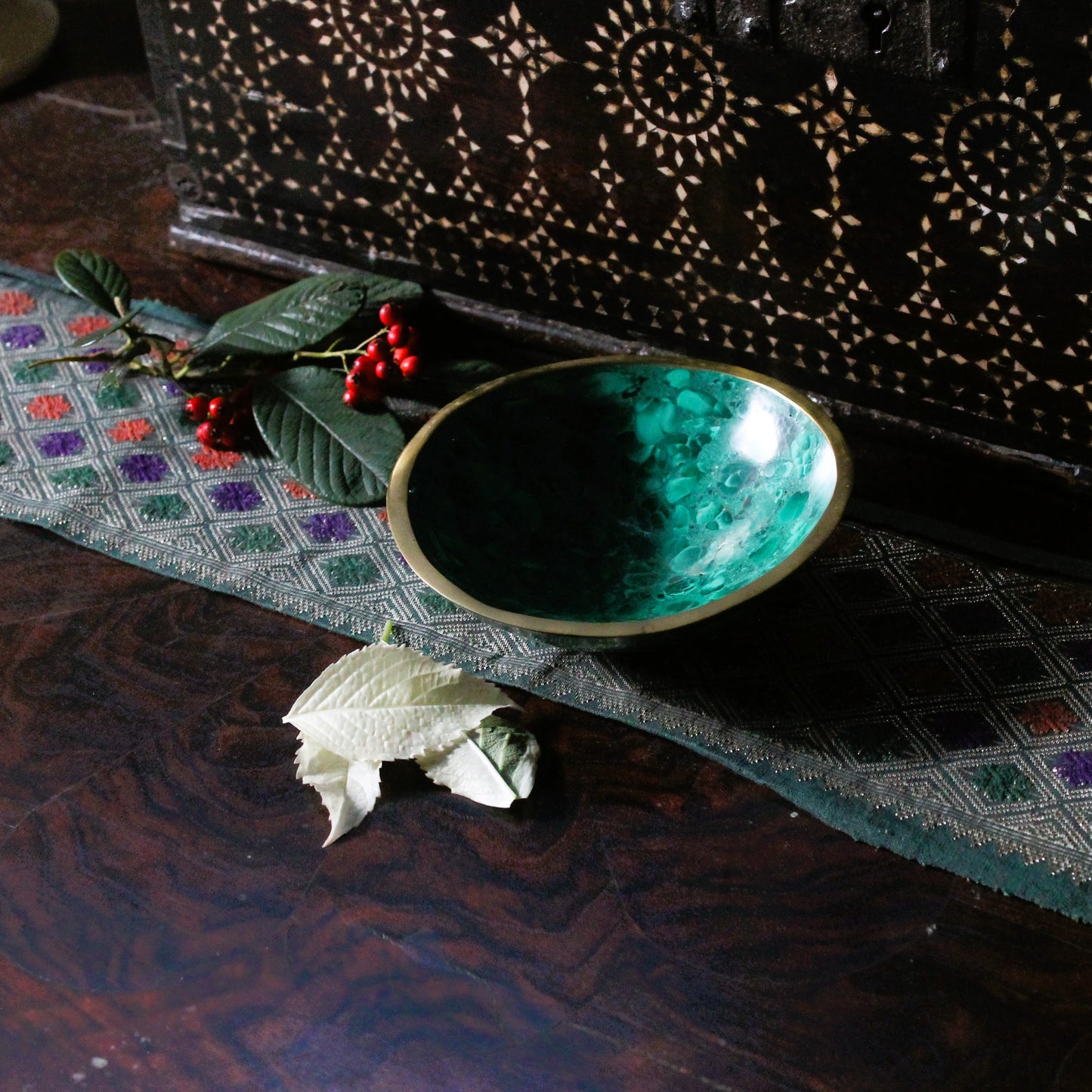 Green decor bowl on a textured surface with decorative elements
