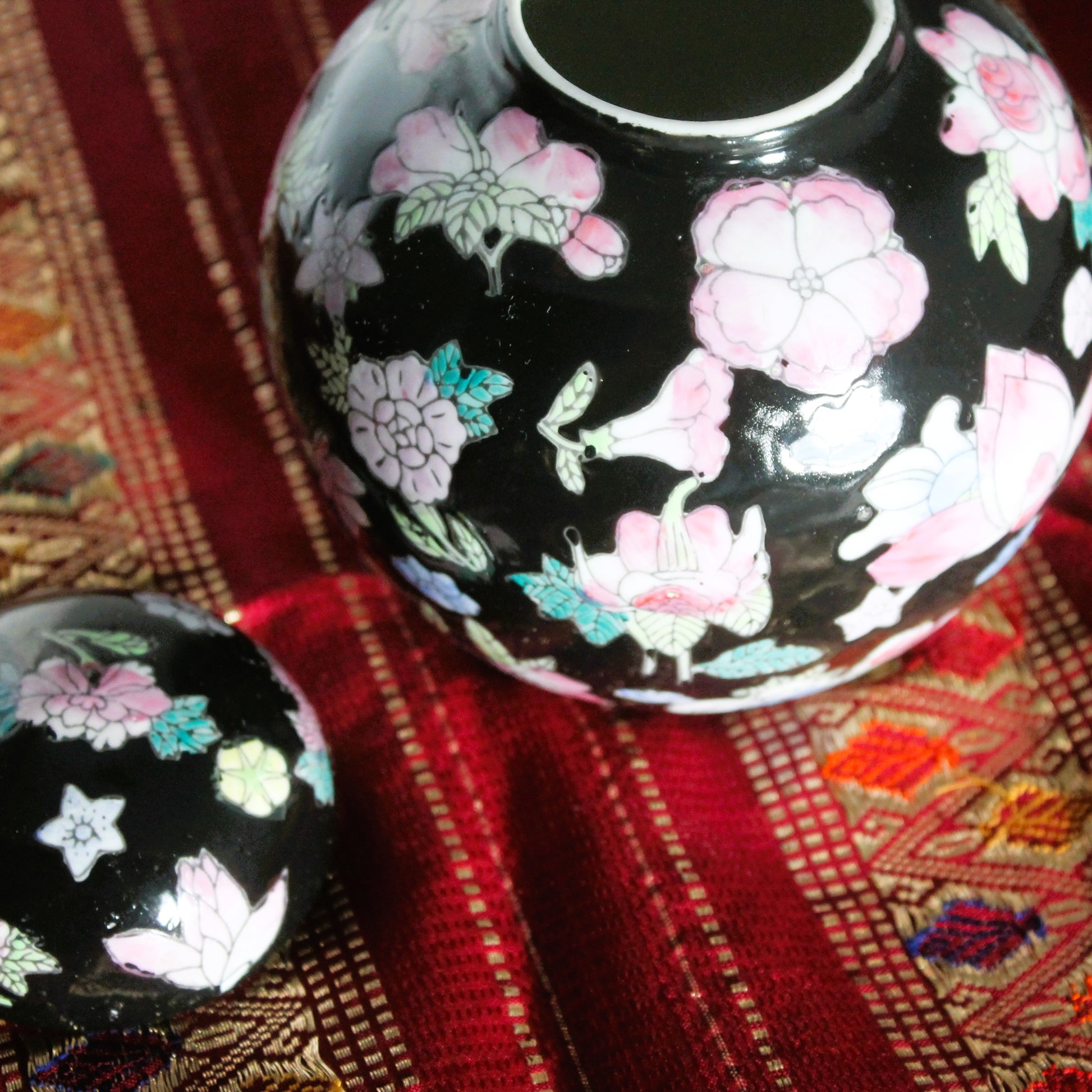Famille noire ginger jar with lid on a red cloth