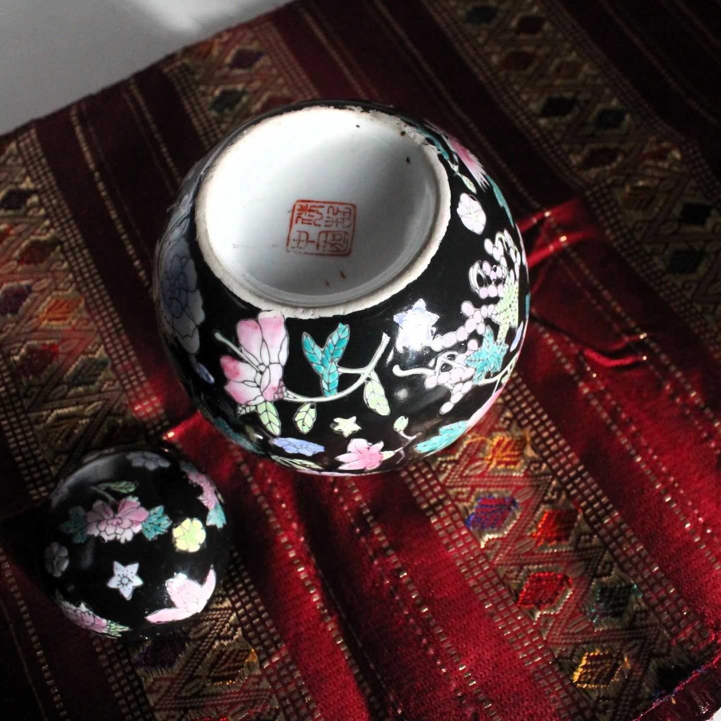 chinese ginger jar with lid upside down on red cloth