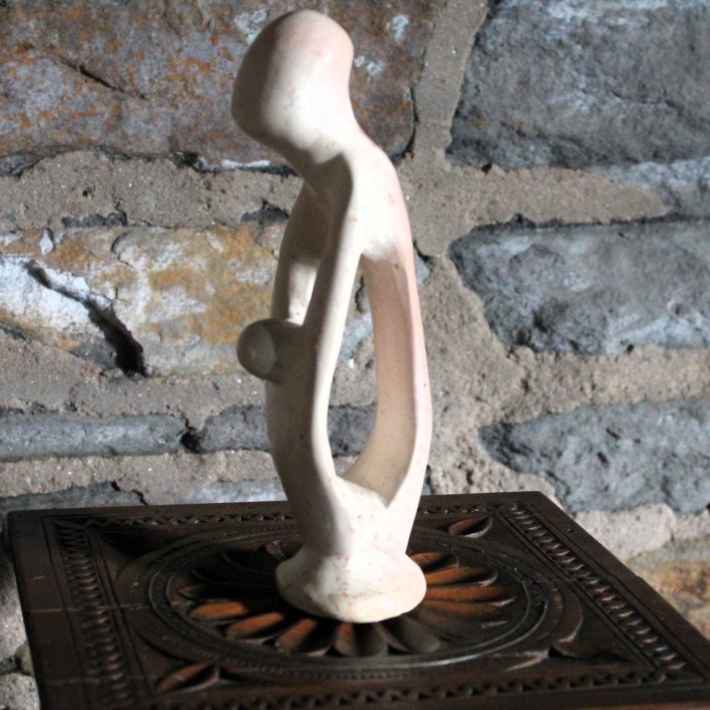 Abstract sculpture of amother and child on a textured stone background