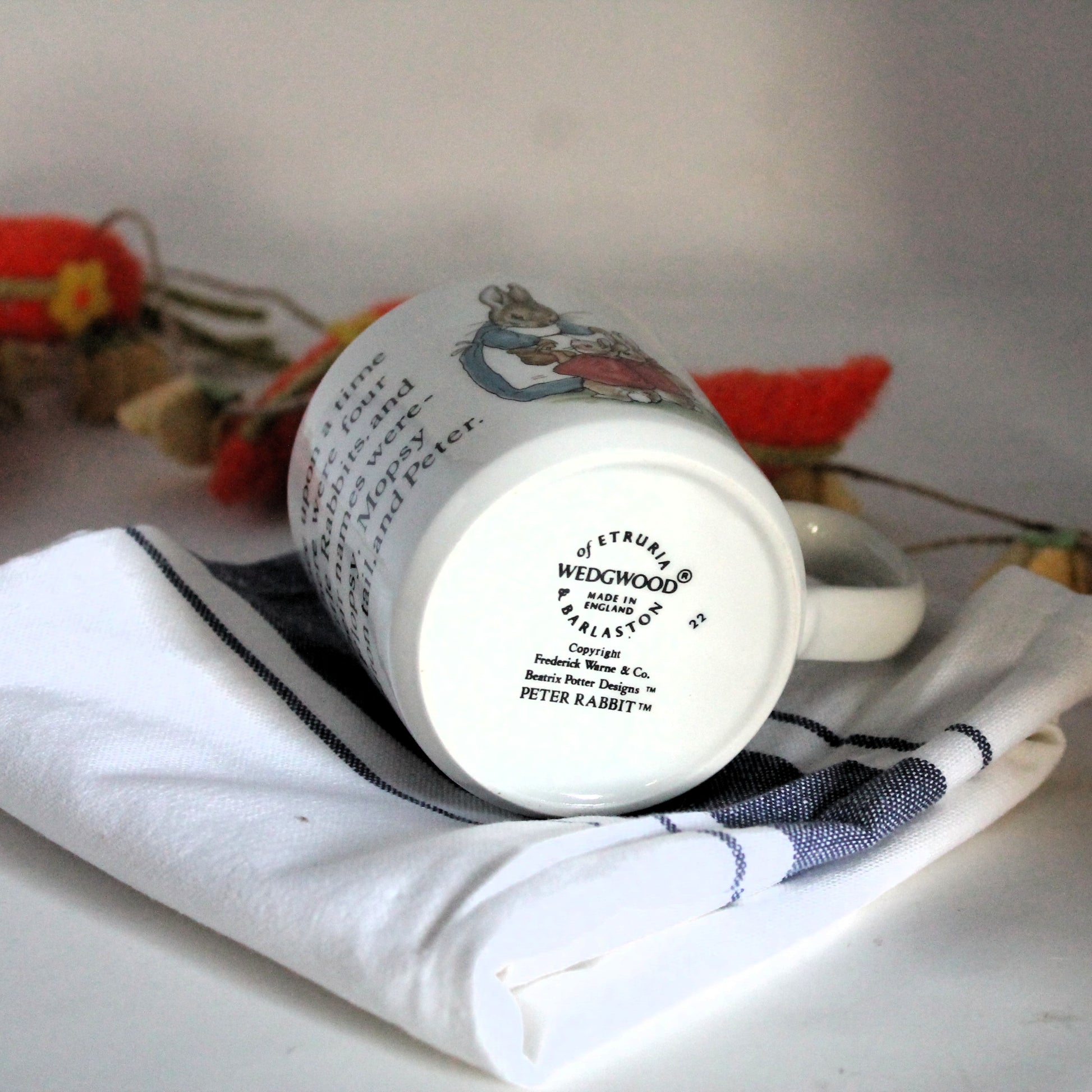 Bottom of a mug showing the Wedgewood stamp, resting on a white and blue tea-towel