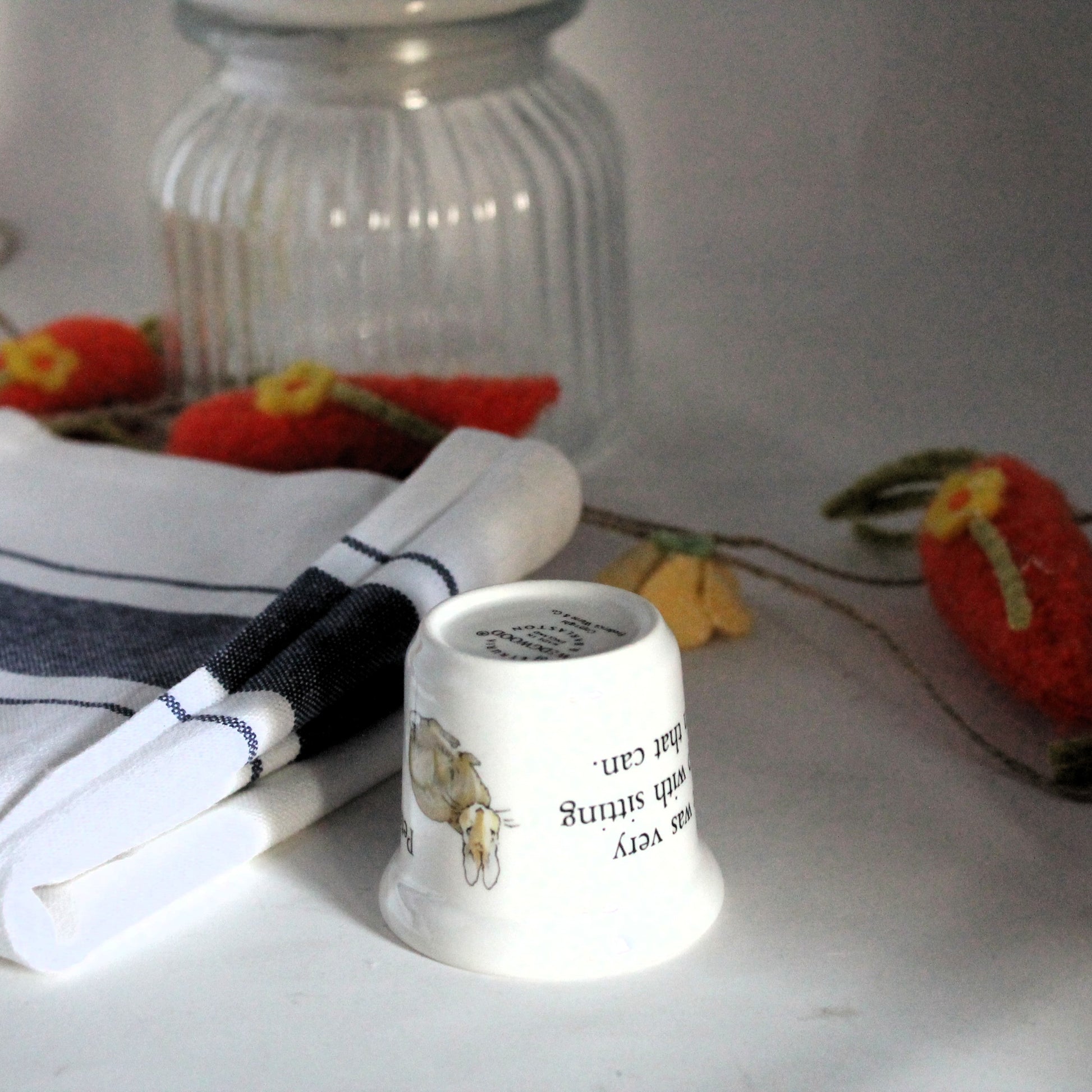 Beatrix Potter porcelain egg cup next to a teatowel