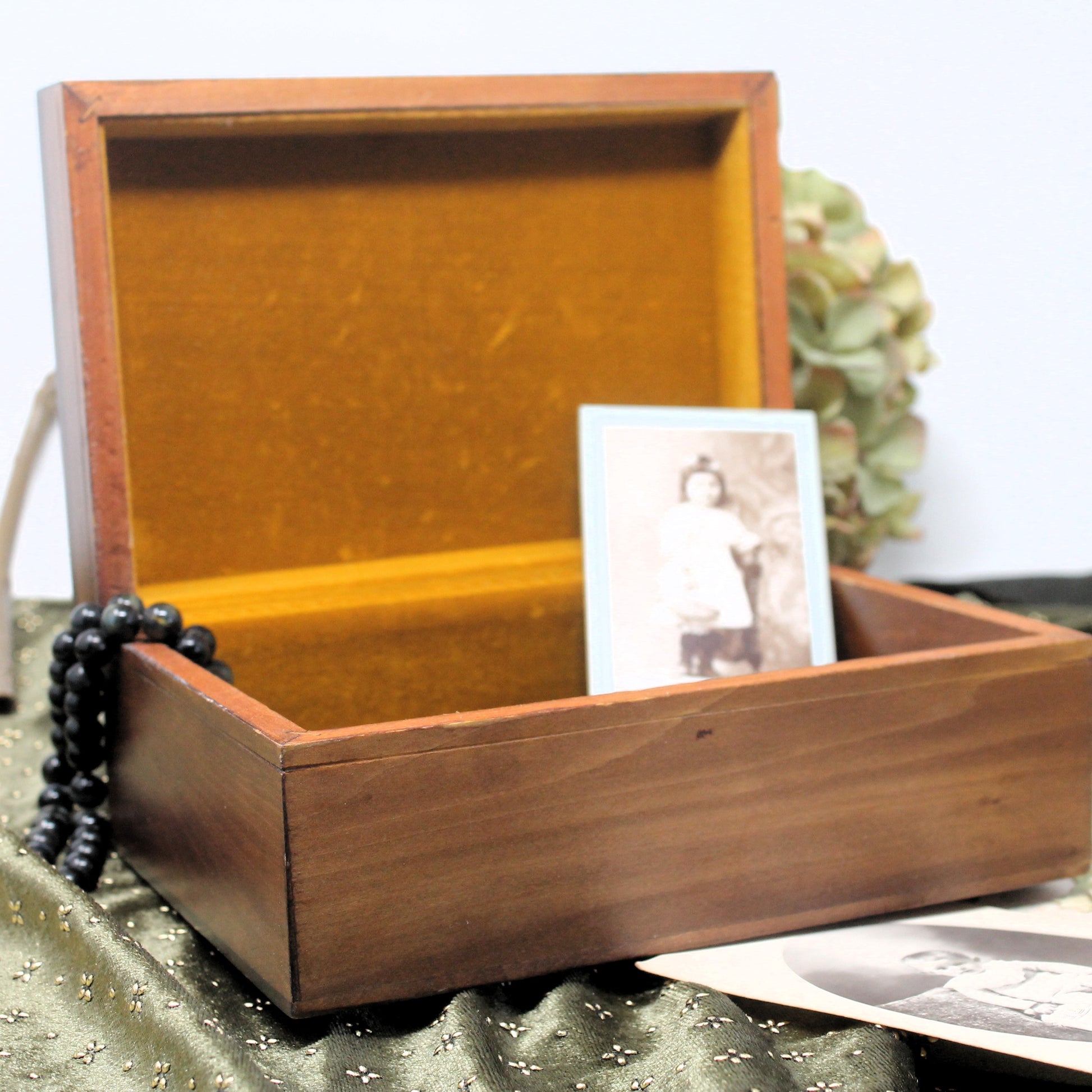 Wooden jewellery box with a photo inside on a textured surface