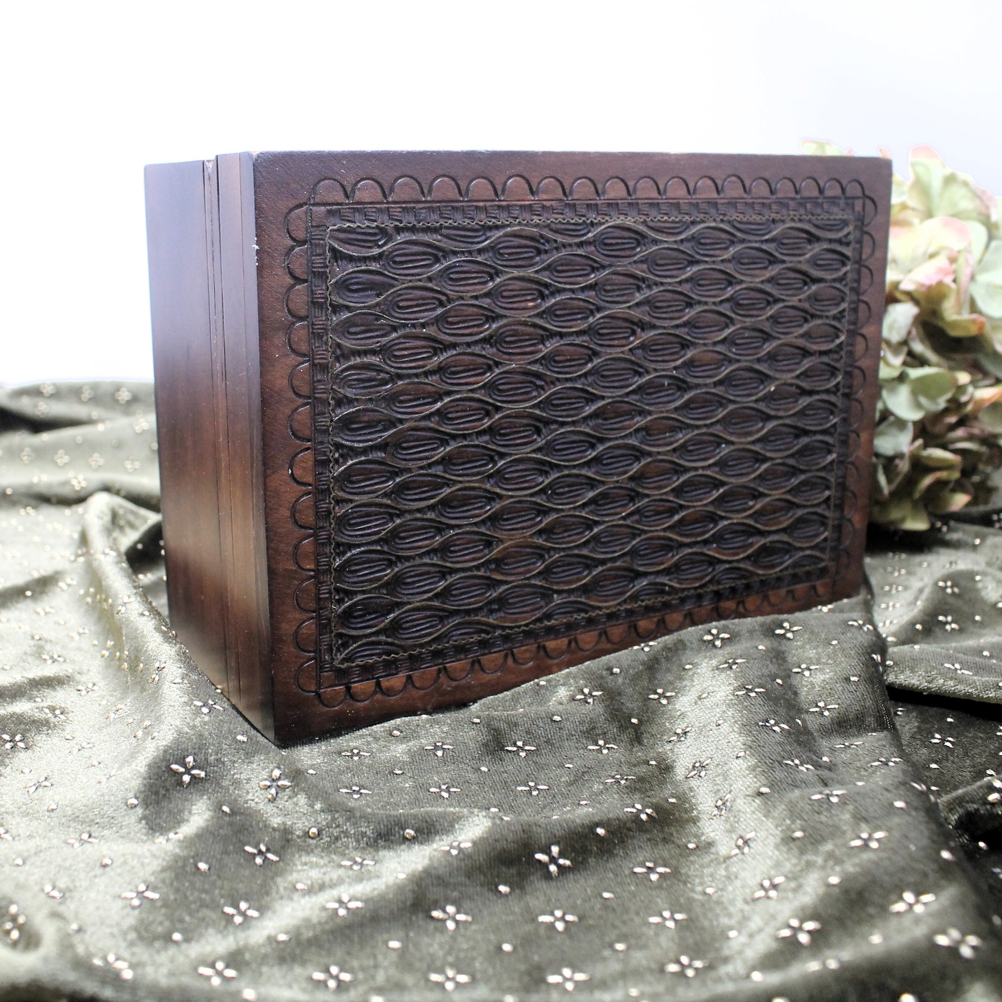 Wooden box made in the Holy Land with intricate carvings on a textured fabric background