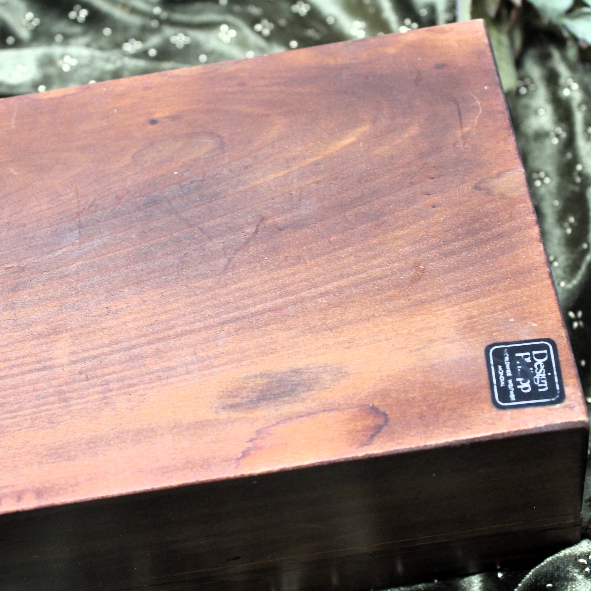 Wooden box with a Philipp Worldwide brand label on a dark background