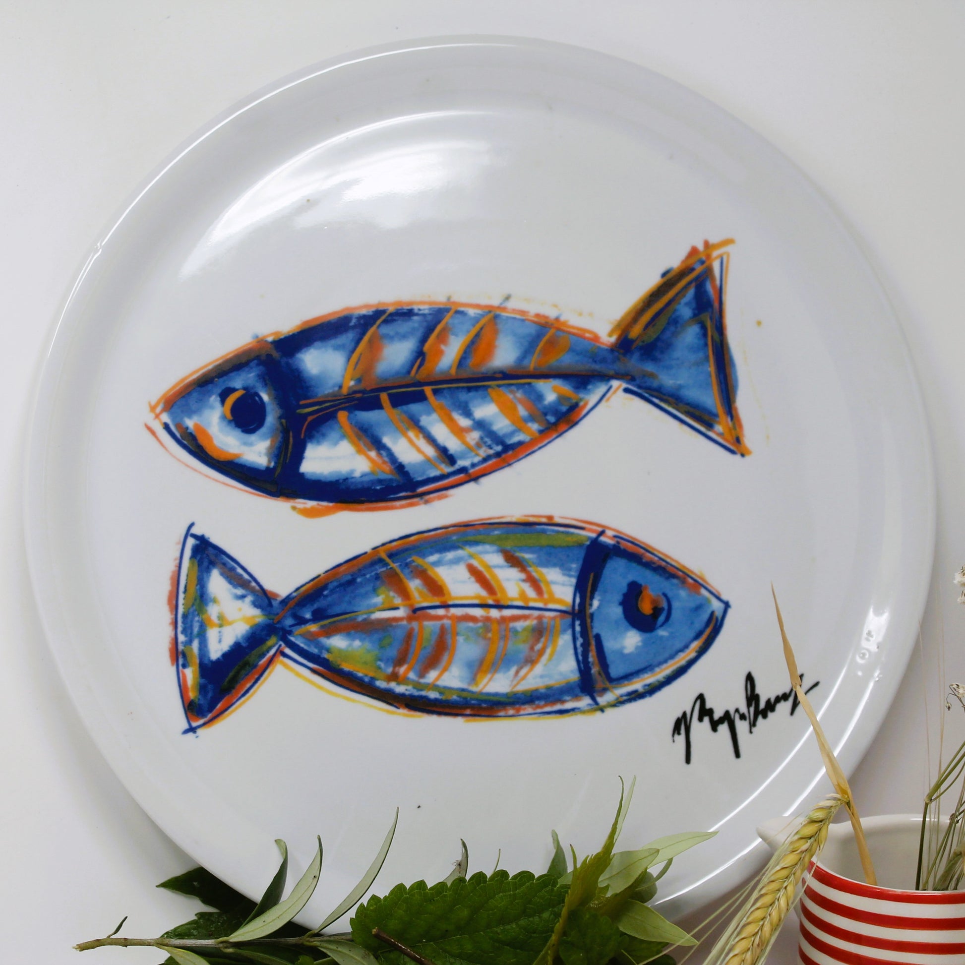 White plate with blue and orange fish design on a white background