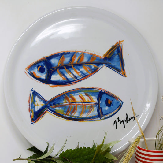 White plate with blue and orange fish design on a white background