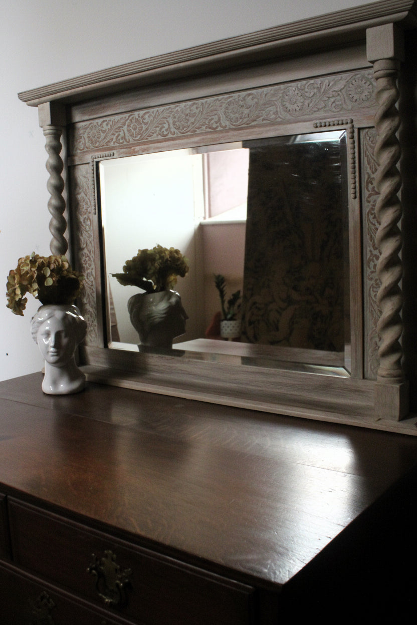 Decorative mirror with wooden frame on a dark surface