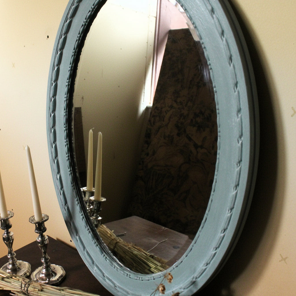 Round mirror with decorative frame on a wall