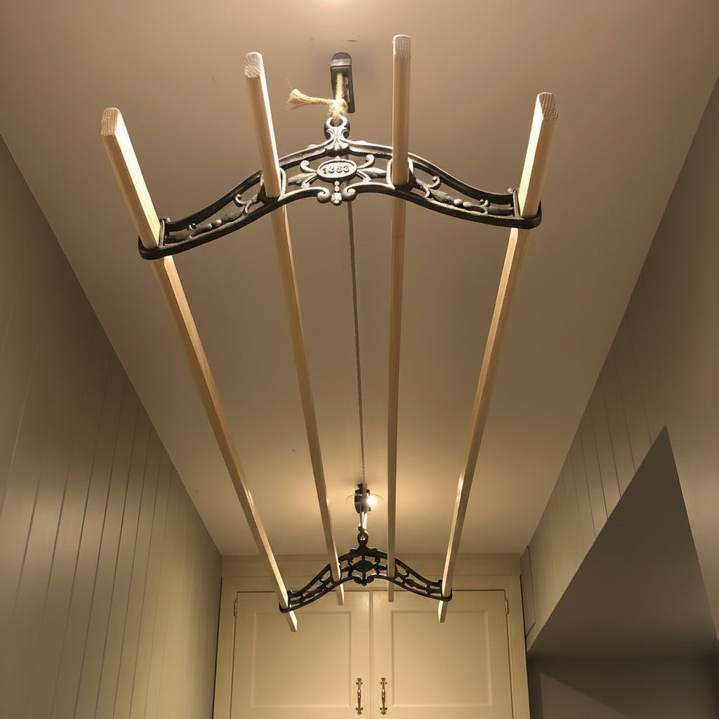 A ceiling-mounted  clothes airer with four wooden poles, a black metal support frame, photographed from below against an indoor wall and ceiling.