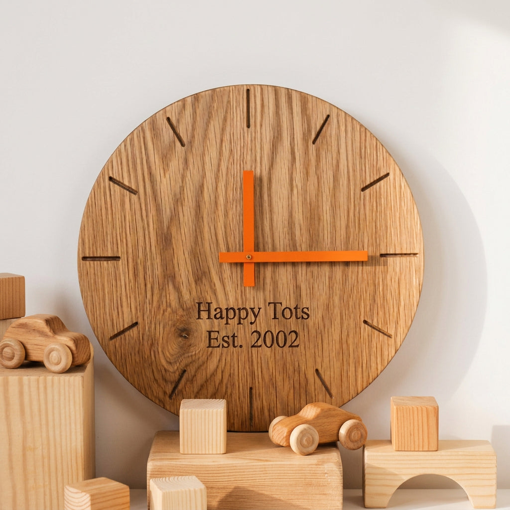 A round wooden wall clock with a natural oak grain finish, custom engraved text reading 'Dalby Forest 3/6/2021', and dark metal hands, styled on a white background with decorative blocks and a green glass bottle.