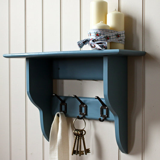 A blue wall shelf for hallway shown with keys and candles